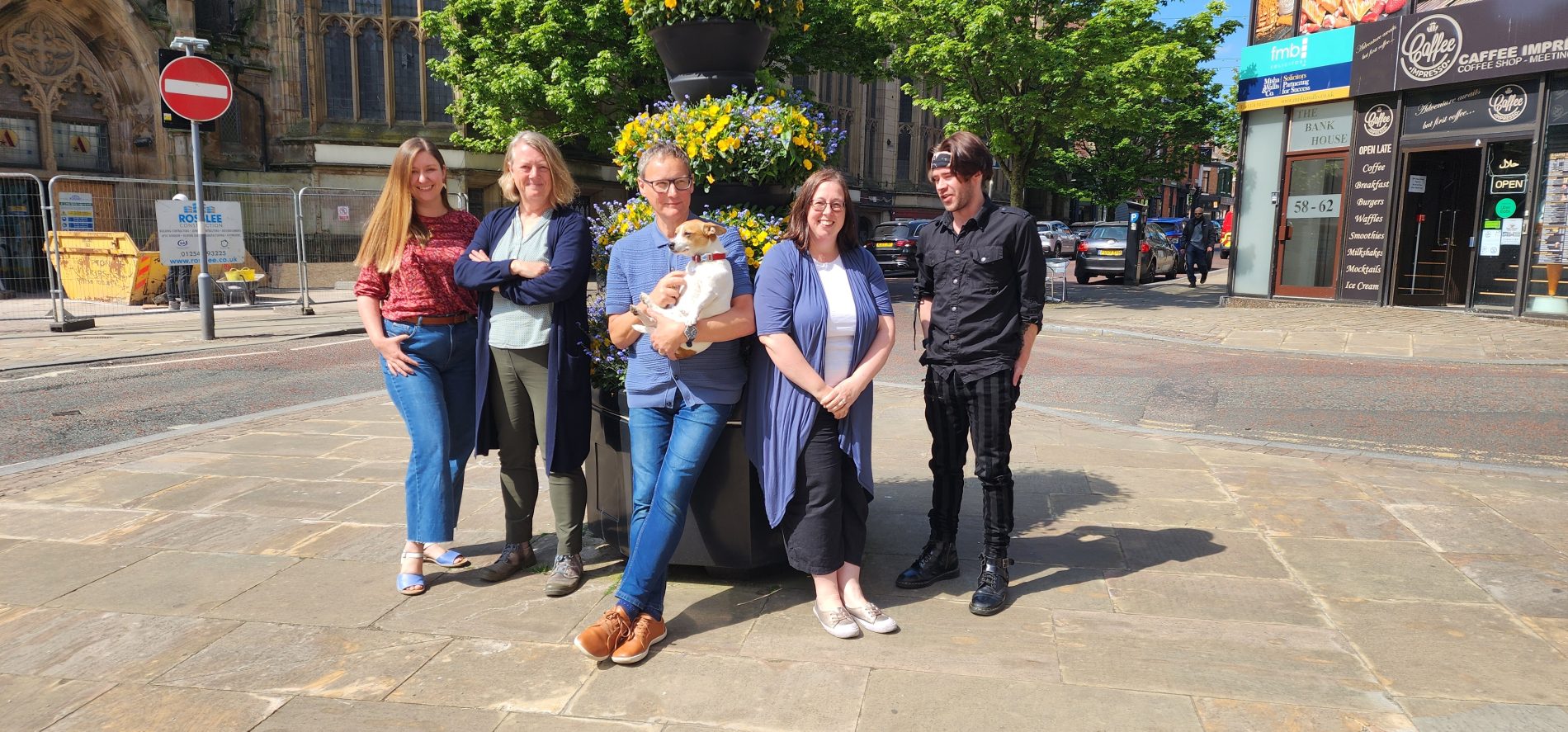 A picture of five people and a dog